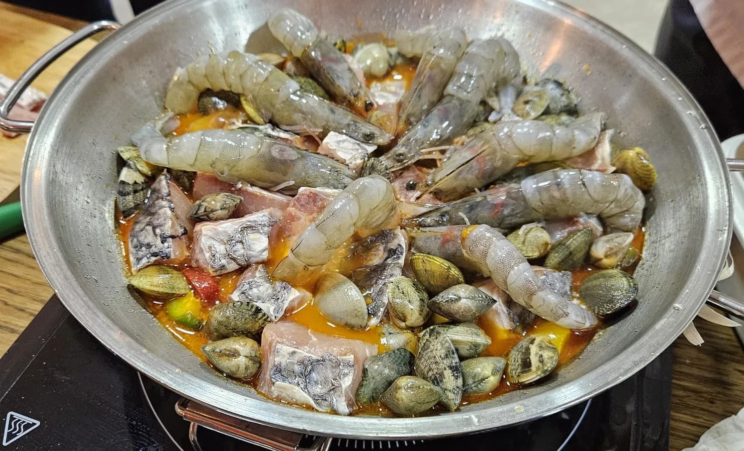 Prawns, clams and fish arranged in a copper cataplana before cooking